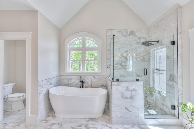 bathroom with a marble finish shower, vaulted ceiling, and marble finish floor