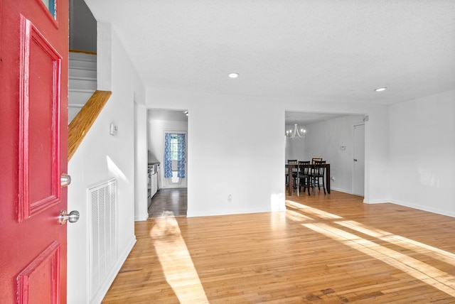 foyer featuring light wood finished floors, recessed lighting, visible vents, and a chandelier