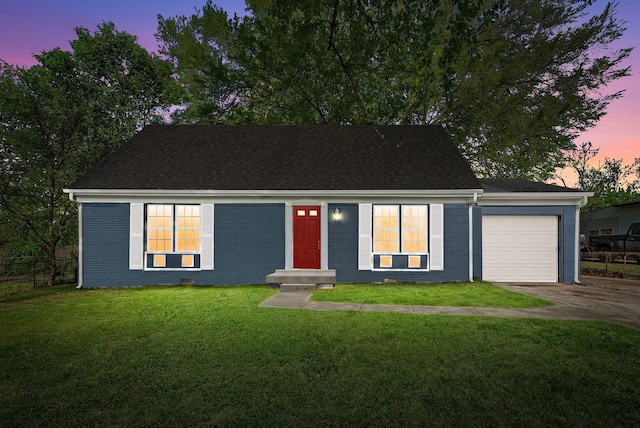 view of front facade with a yard, brick siding, fence, a garage, and driveway