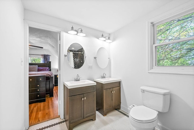 full bath with two vanities, a healthy amount of sunlight, and a sink