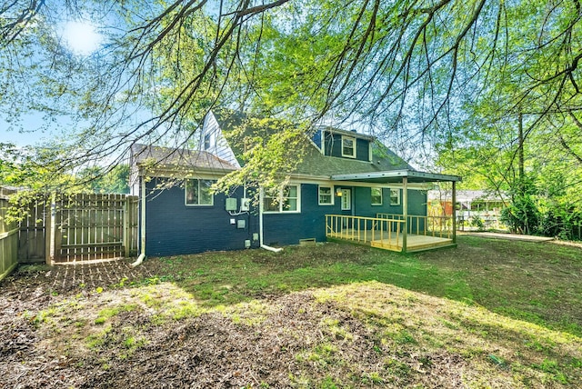 rear view of property with fence, a yard, and brick siding