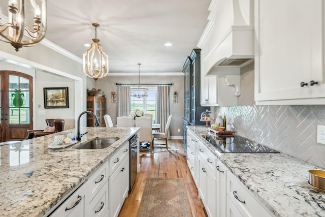 kitchen with a notable chandelier, a sink, black electric cooktop, stainless steel dishwasher, and custom exhaust hood