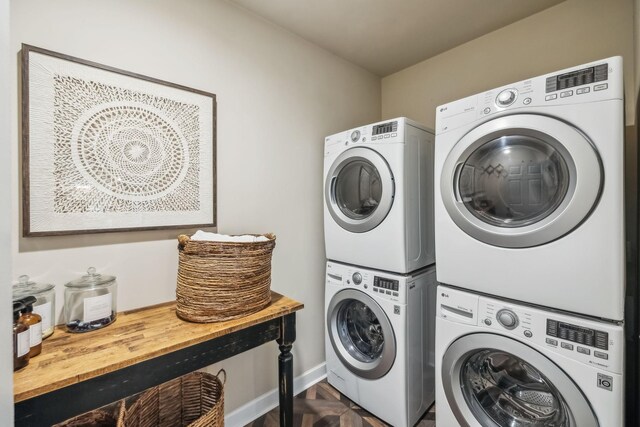 washroom with stacked washer / drying machine, baseboards, and laundry area