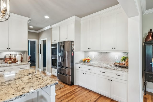 kitchen featuring decorative backsplash, appliances with stainless steel finishes, white cabinetry, recessed lighting, and light wood-style flooring