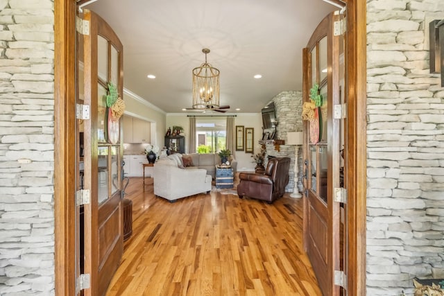 living area featuring light wood-type flooring, recessed lighting, crown molding, and a notable chandelier
