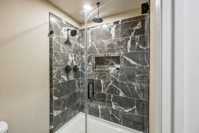bathroom featuring toilet and a shower stall