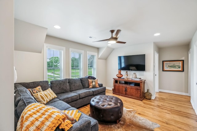 living room featuring baseboards, a ceiling fan, light wood-type flooring, and visible vents