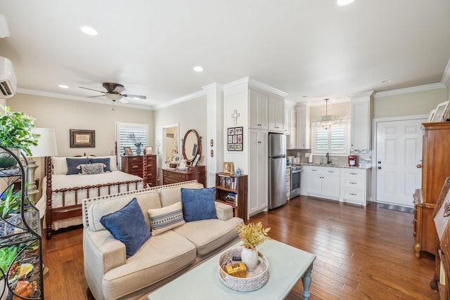 living room with ornamental molding, ceiling fan with notable chandelier, recessed lighting, and dark wood-style floors