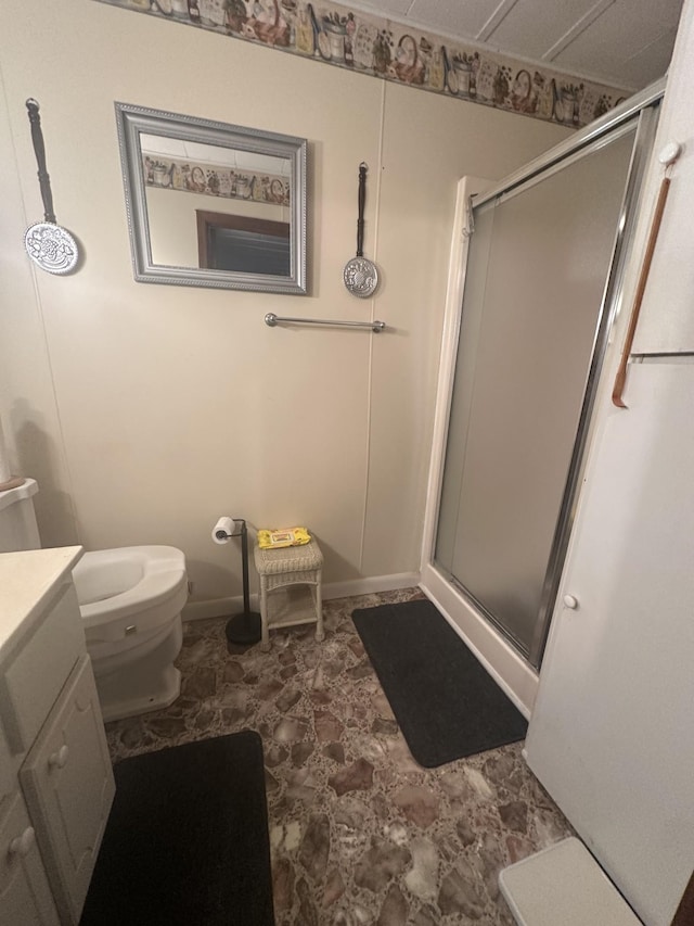 full bath featuring baseboards, a shower stall, toilet, and vanity