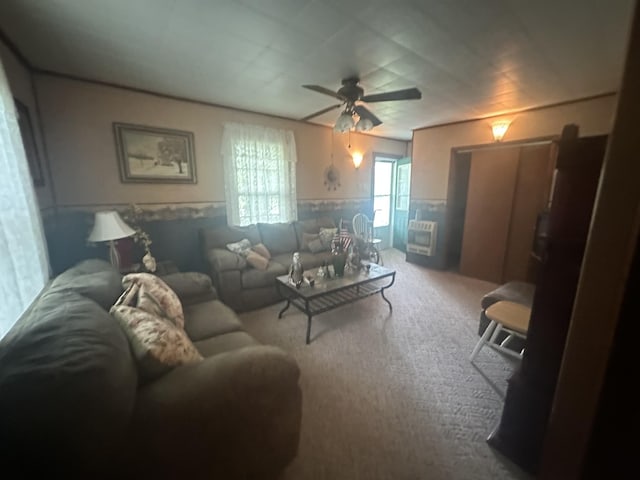 carpeted living room featuring ceiling fan and a wainscoted wall