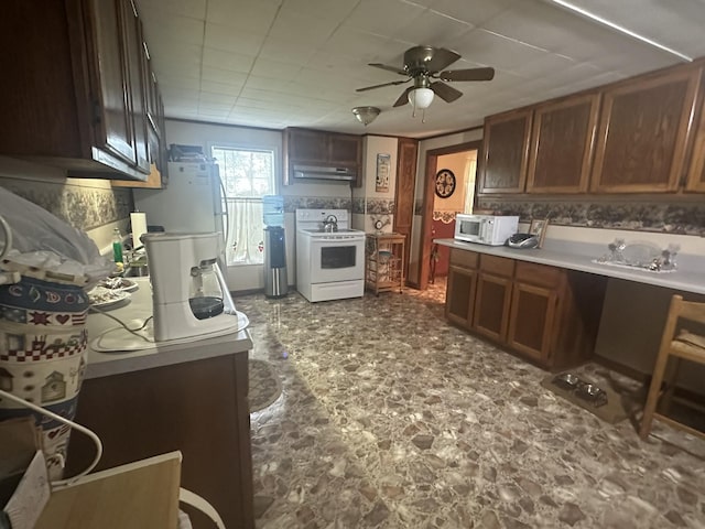 kitchen with ceiling fan, white appliances, under cabinet range hood, and light countertops