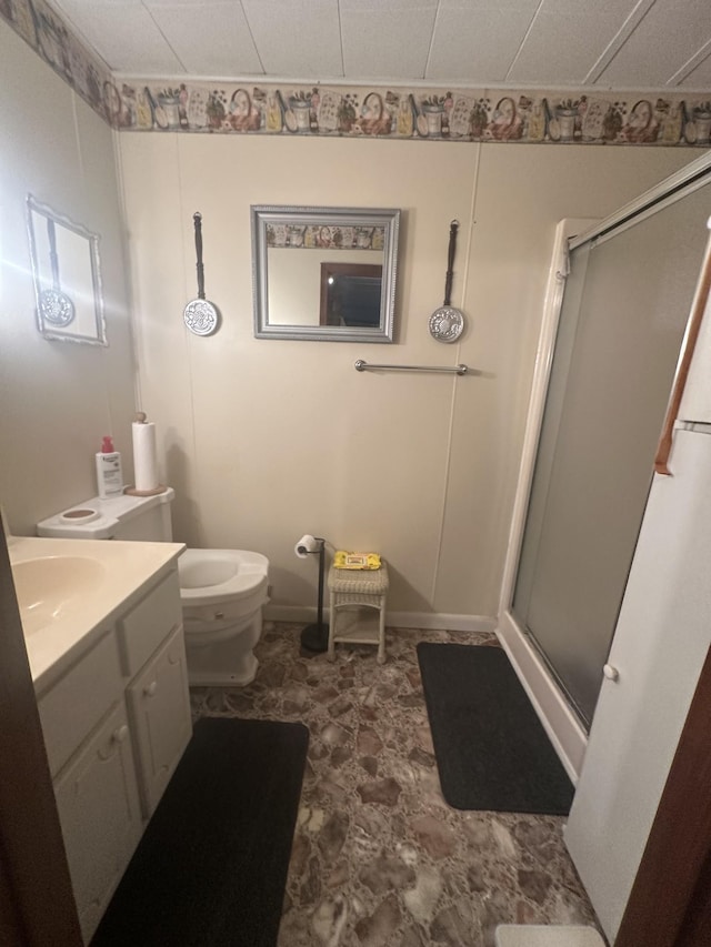 bathroom featuring toilet, a shower stall, and vanity