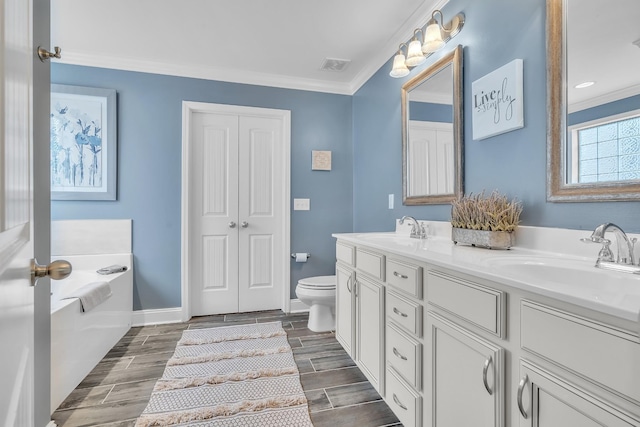 bathroom featuring visible vents, toilet, double vanity, and a sink