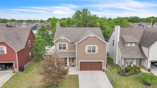 traditional-style house with a chimney, a front lawn, concrete driveway, and an attached garage
