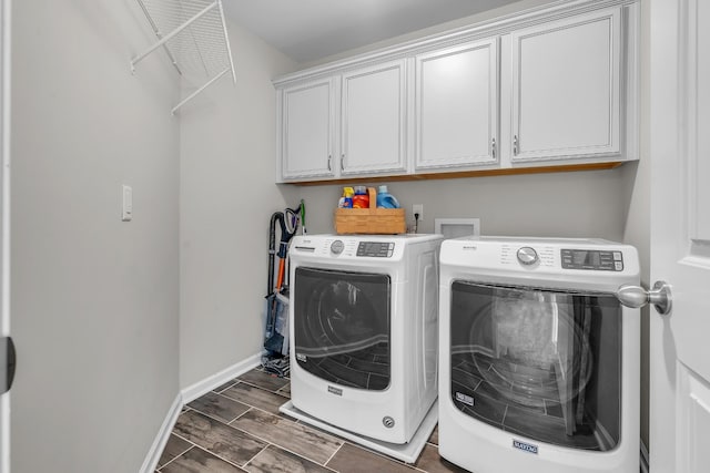 laundry room featuring baseboards, wood tiled floor, cabinet space, and washer and clothes dryer