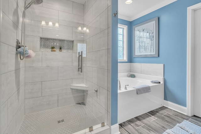 bathroom with a garden tub, a shower stall, ornamental molding, and baseboards