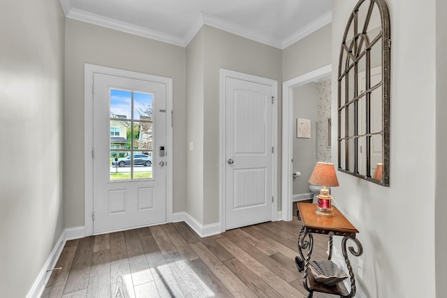 entrance foyer with hardwood / wood-style flooring, ornamental molding, and baseboards