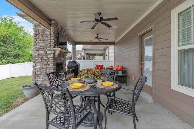 view of patio / terrace with outdoor dining space, an outdoor fireplace, a fenced backyard, and a ceiling fan