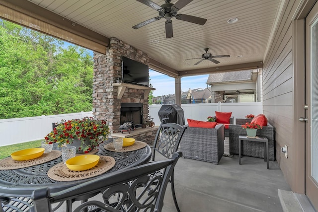 view of patio / terrace featuring an outdoor stone fireplace, a ceiling fan, a grill, and a fenced backyard