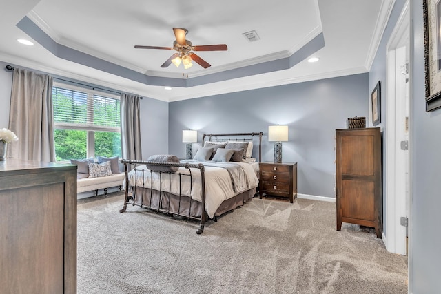 bedroom featuring carpet, baseboards, visible vents, crown molding, and a tray ceiling