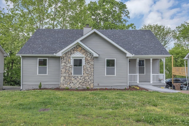 view of front of house featuring a porch, a front yard, a chimney, and roof with shingles