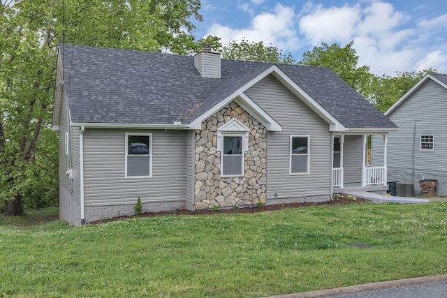 view of front of property with a chimney, a porch, a shingled roof, central AC unit, and a front lawn