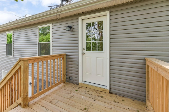 view of exterior entry with a wooden deck