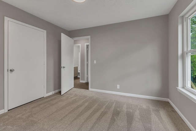 unfurnished bedroom featuring carpet and baseboards