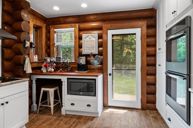 209 Green Valley Blvd, Franklin, TN 37064 - kitchen featuring stainless steel double oven, built in microwave, dark wood finished floors, log walls, and white cabinetry