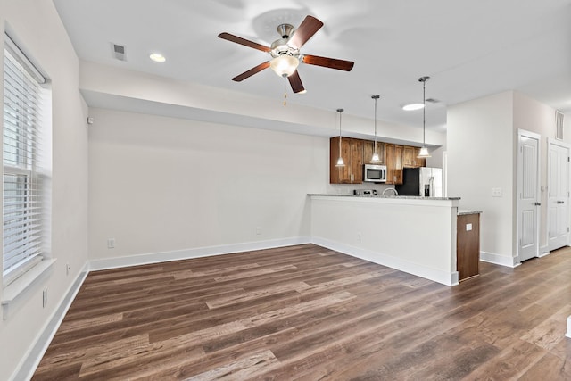 kitchen with stainless steel appliances, ceiling fan, baseboards, a peninsula, and dark wood-type flooring
