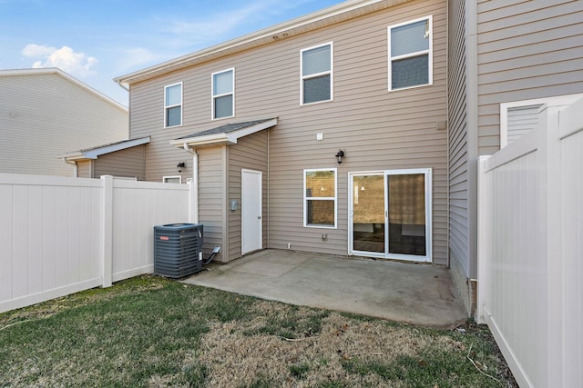 back of house with central AC, fence, a lawn, and a patio area