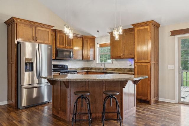 kitchen with backsplash, appliances with stainless steel finishes, dark wood-type flooring, and brown cabinets
