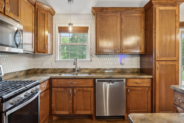 kitchen with brown cabinets, appliances with stainless steel finishes, and a sink