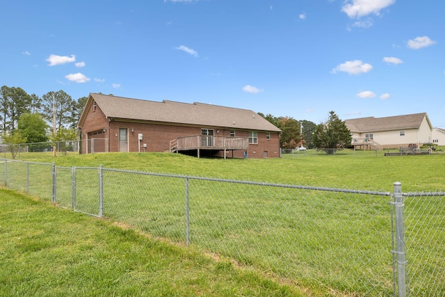 view of yard with a fenced backyard, a wooden deck, and a garage