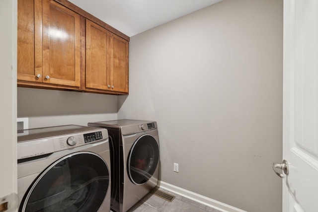 laundry area with baseboards, cabinet space, and independent washer and dryer