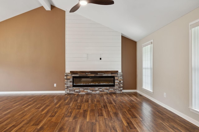 unfurnished living room featuring a fireplace, wood finished floors, lofted ceiling with beams, and ceiling fan