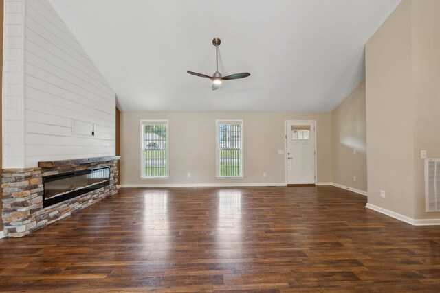 unfurnished living room with wood finished floors, a ceiling fan, a stone fireplace, and lofted ceiling