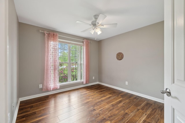 empty room featuring dark wood-style floors, baseboards, and a ceiling fan