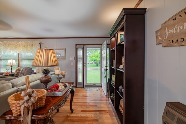 living area with light wood-style floors and crown molding