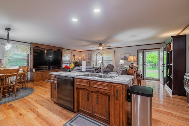 kitchen with an island with sink, light countertops, dishwasher, a sink, and open floor plan