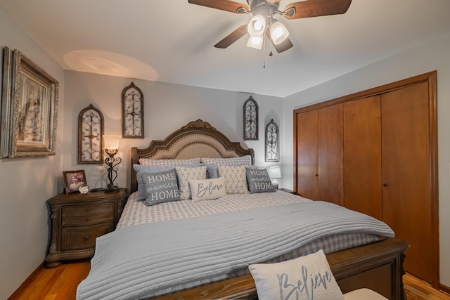 bedroom with a ceiling fan, light wood-style flooring, baseboards, and a closet