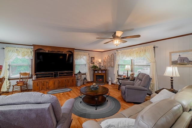 living area with a wealth of natural light, ceiling fan, and ornamental molding