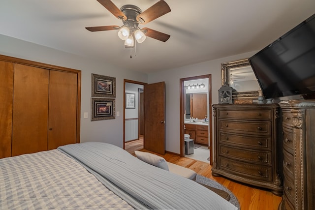 bedroom with connected bathroom, light wood-style floors, ceiling fan, and a closet