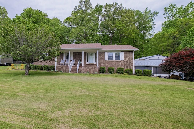 view of front facade featuring a front yard, covered porch, and brick siding
