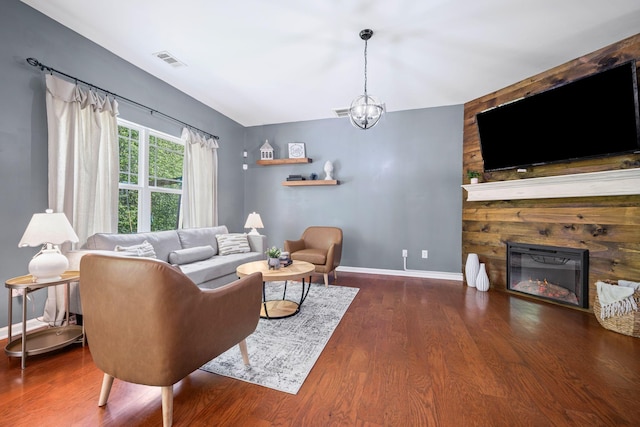 208 Wyburn Pl, Burns, TN 37029 - living room with visible vents, an inviting chandelier, wood finished floors, baseboards, and a stone fireplace