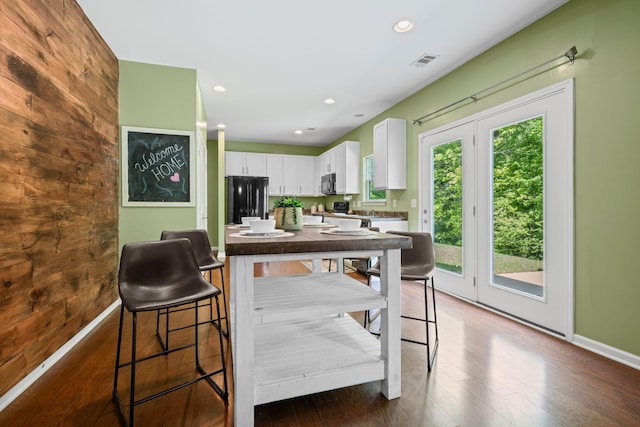 208 Wyburn Pl, Burns, TN 37029 - kitchen featuring visible vents, freestanding refrigerator, dark countertops, stainless steel microwave, and white cabinets