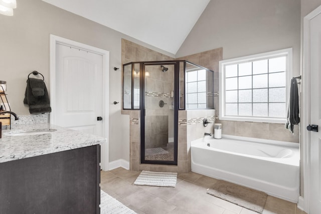 bathroom with a bath, tile patterned flooring, a shower stall, vanity, and lofted ceiling