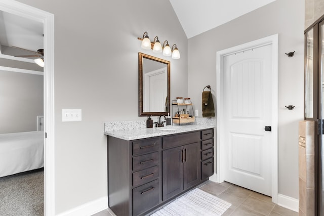 ensuite bathroom with vanity, baseboards, ceiling fan, connected bathroom, and vaulted ceiling
