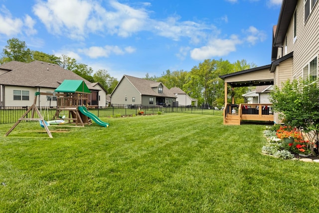 view of yard with a fenced backyard, a playground, a wooden deck, and a residential view