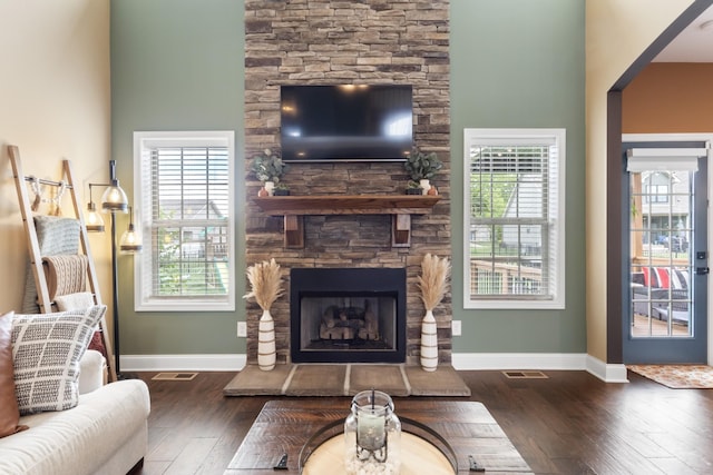 living area with baseboards, plenty of natural light, a fireplace, and dark wood finished floors